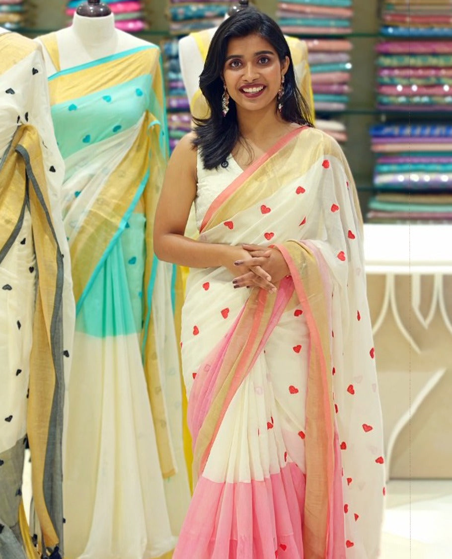 Pink and off-white mul cotton saree featuring a thread heart designed body, complemented by a Kasavu border, without a blouse piece.