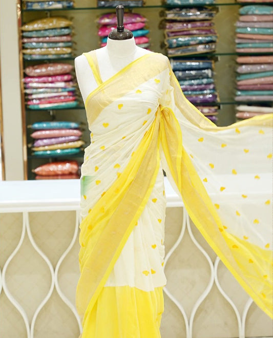 Yellow and off-white mul cotton saree featuring a thread heart designed body, complemented by a Kasavu border, without a blouse piece.