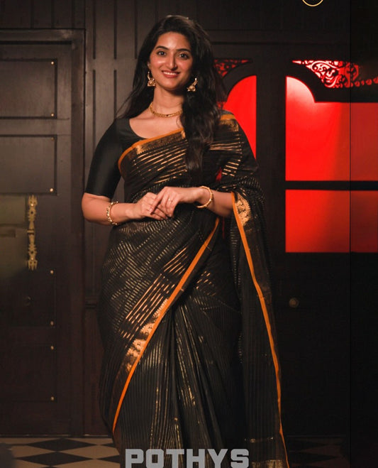 Black colour chettinad cotton saree Highlighting Gold zari striped body, contrast traditional mustard border, paired with matching blouse piece.