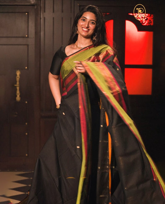 Black colour chettinad cotton saree Highlighting Gold zari striped body, contrast Green colour traditional border, paired with matching blouse piece.