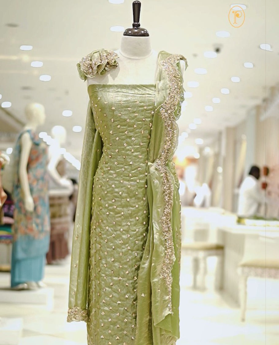 Pastel Green colour Fenty silk salwar material highlighting gold sequins on body and scalp design on border, matching dupatta with scalp design, paired with matching bottom.