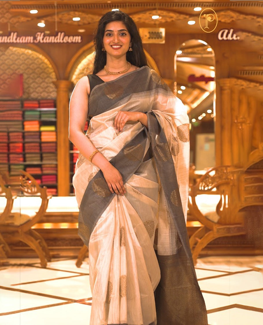 Cream colour Semi Jute saree featuring bold zari motifs across the body with a black colour parallel panel border, paired with a running blouse piece.