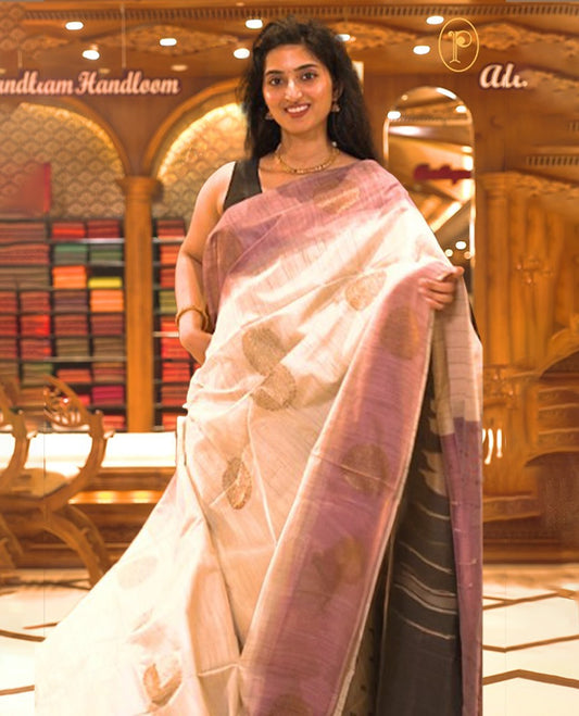 Cream colour Semi Jute saree featuring bold zari motifs across the body with a Purple colour parallel panel border, paired with a running blouse piece.