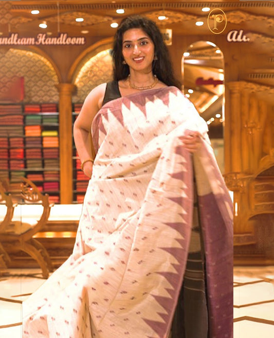 Cream colour Semi Jute saree featuring thread motifs across the body with a Purple colour traditional temple border, paired with a running blouse piece.