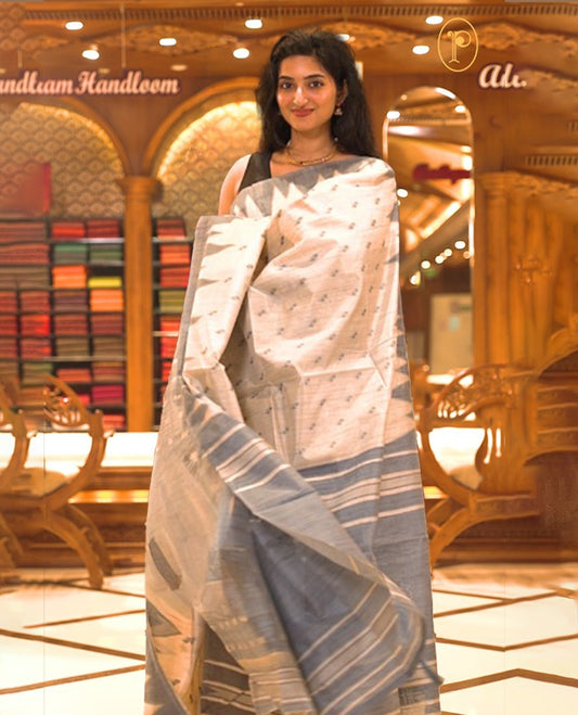 Cream colour Semi Jute saree featuring thread motifs across the body with a Blue colour traditional temple border, paired with a running blouse piece.