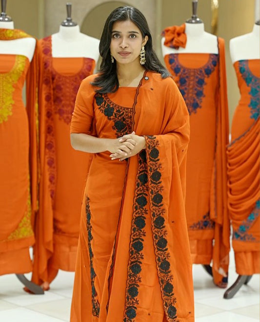 Orange colour georgette salwar suit material featuring intricate Black floral thread embroidery on the neckline and side opening, complemented with a matching bottom and dupatta. Comes with lining included for added comfort and finish.