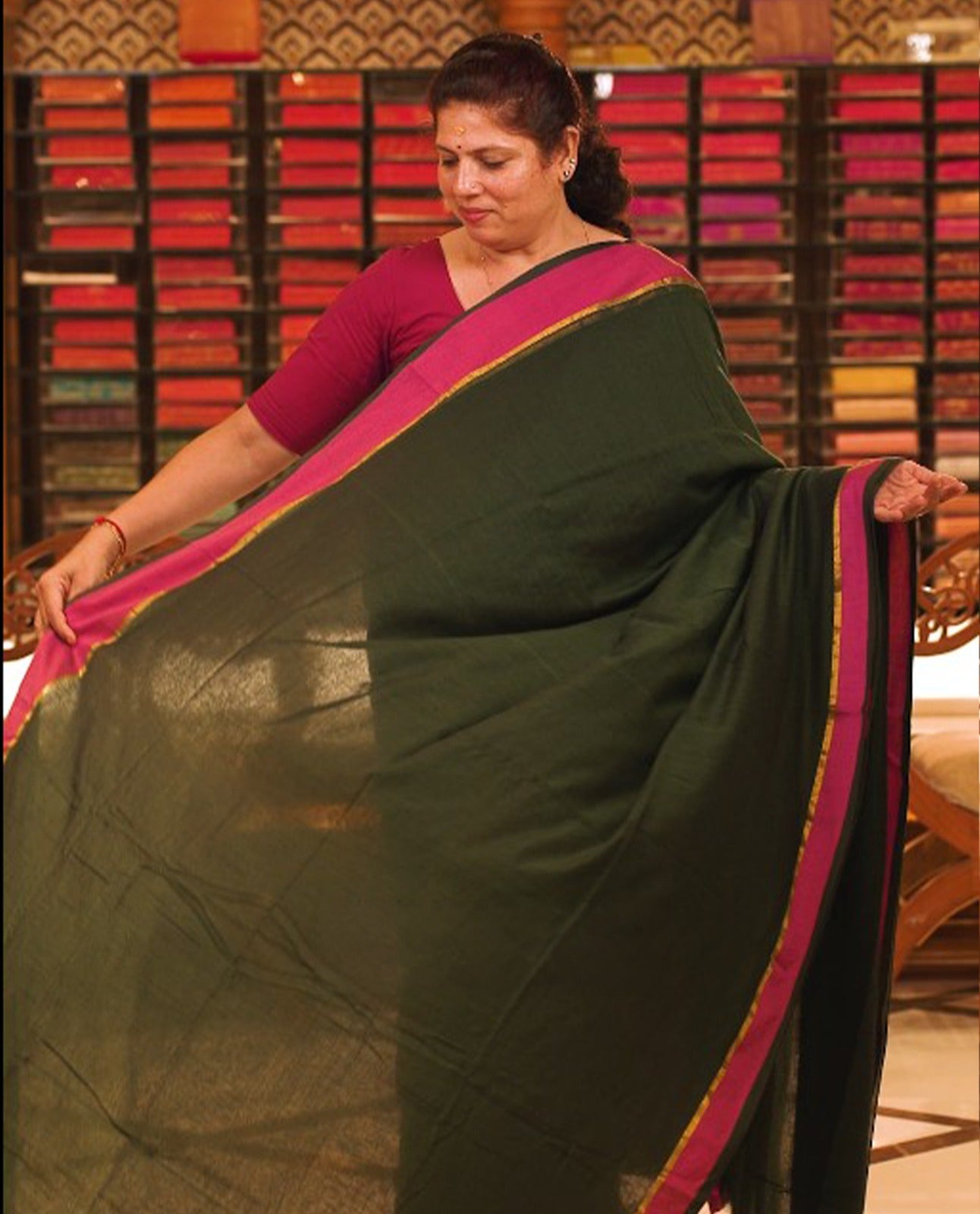 Bottle green colour Mul Cotton saree featuring a simple plain body with a contrast border, offering a classic and elegant look. Comes without a blouse piece.