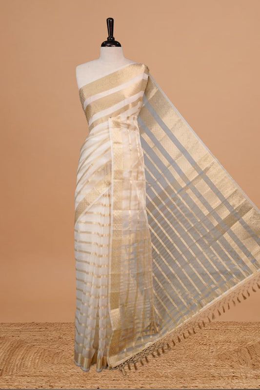 White Colour Semi Organza Saree Featuring Elegant Gold zari Stripes Detailing on body, Traditional border, comes with matching blouse piece.