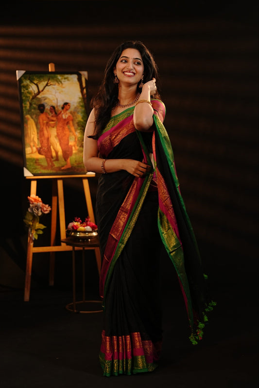 Black Colour Mul Cotton saree featuring Elegant plain body, contrast Green & Pink colour with gold zari traditional border.