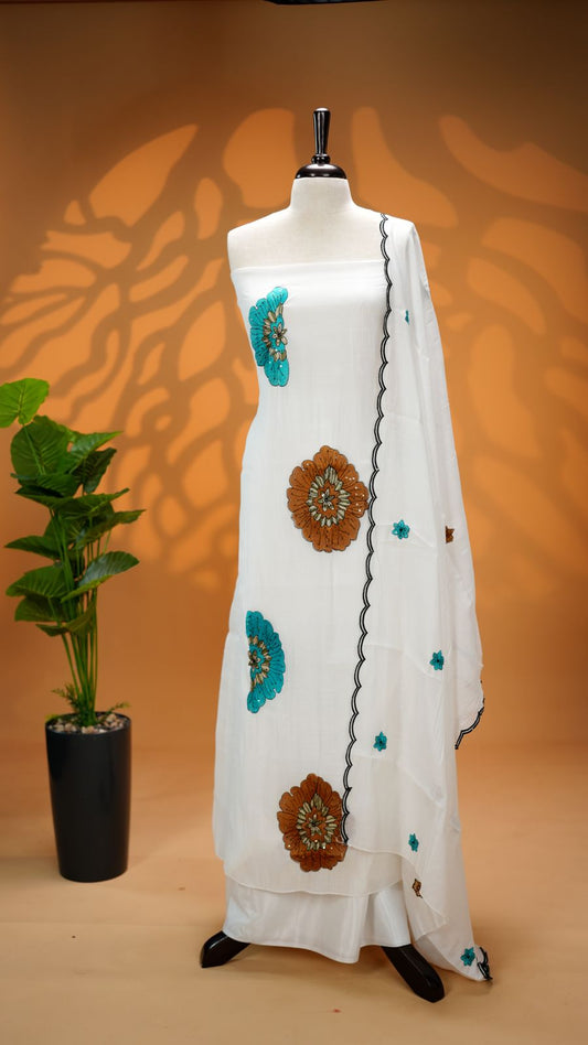 White Colour Mul Chanderi Salwar Material Featuring Peach Colour Floral Thread Work on body, paired with matching santoon Material Bottom & Floral thread Worked motifs And Scallop Embroidery Black Border Dupatta.