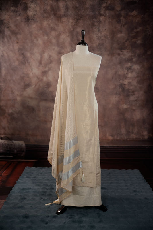 Solid Silver colour Semi Tissue Silk Salwar Material featuring plain body, paired with Santoon bottom and Small Golden line with silver lin detailed Dupatta with tassels.