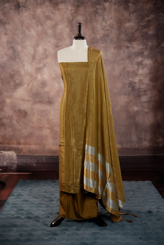 Gold Olive colour Semi Tissue Silk Salwar Material featuring plain body, paired with Santoon bottom and Small Golden line with silver lin detailed Dupatta with tassels.