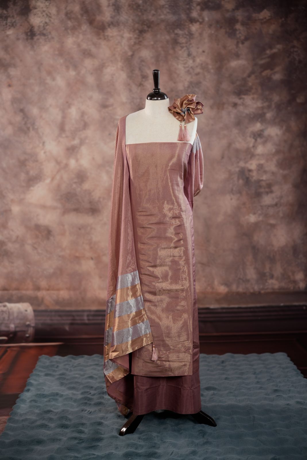 Onion pink colour Semi Tissue Silk Salwar Material featuring plain body, paired with Santoon bottom and Small Golden line with silver lin detailed Dupatta with tassels.
