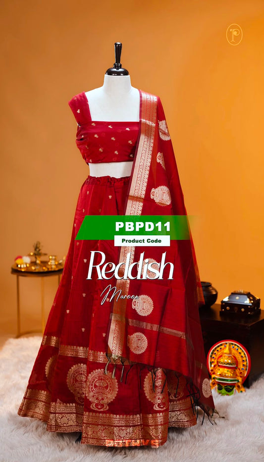 Reddish Maroon colour Chanderi Silk semi stitched Dhavani Set featuring beautiful Buttas on skirt With Kathakali Design border, same material dupatta with Same design & blouse.