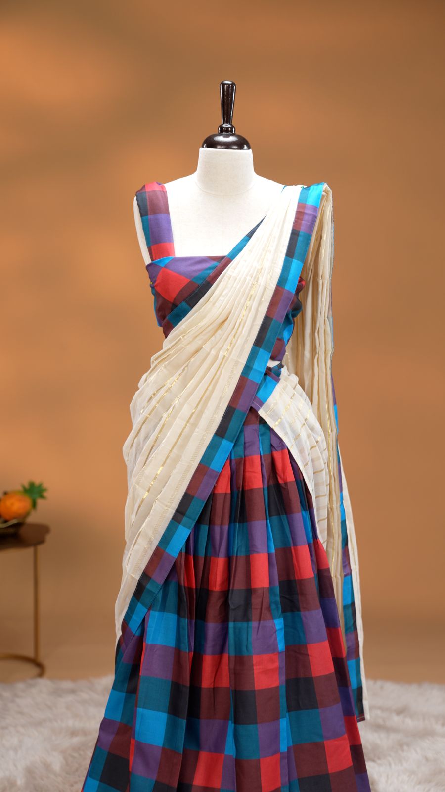 Red, Blue, Purple & Black colour Dhavani set featuring Check pattern skirt, comes with Matching blouse piece, Paired with white Dupatta With gold zari strip & Madras check border.