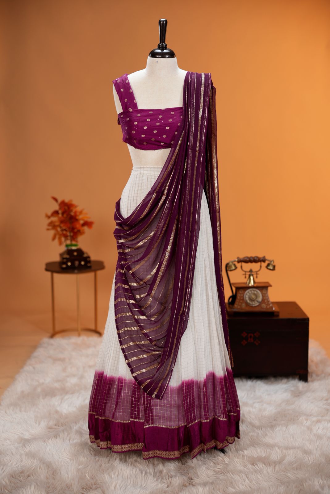 Magenta colour Georgette Dhavani material featuring white skirt with Check pattern & contrast border, Small floral work on blouse piece, same colour dupatta with strips.