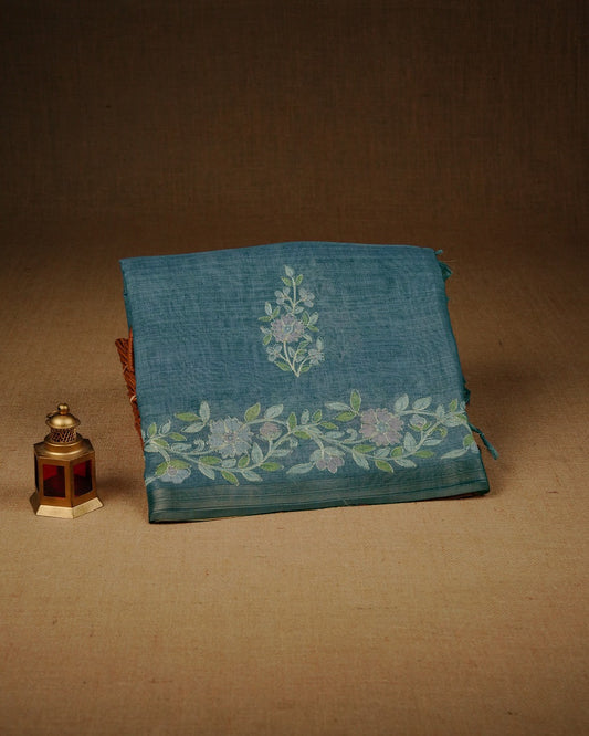 Teal mist colour linen tissue saree featuring Floral design with Aari work & contrast simple border, comes with matching blouse piece.