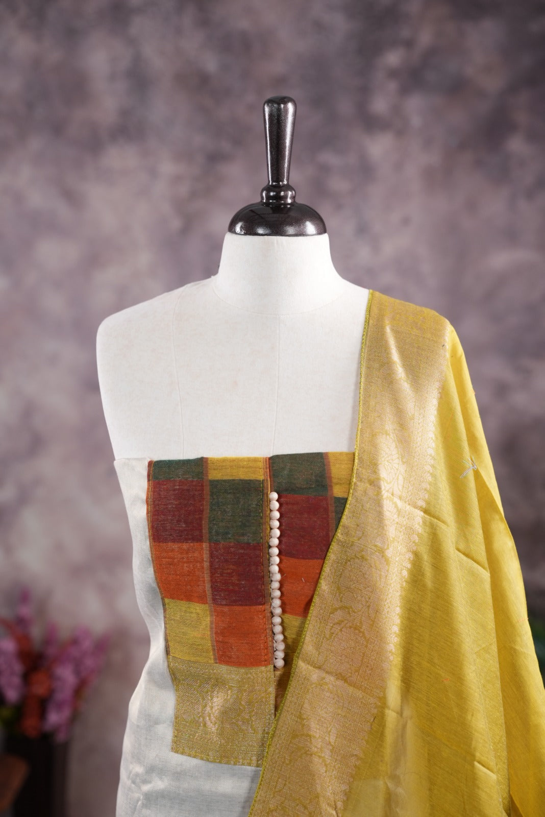 Yellow colour tissue Madras check salwar material featuring a plain body with a classic Kasavu border, paired with a Chanderi dupatta adorned with a matching Kasavu border and a Shantoon fabric bottom.