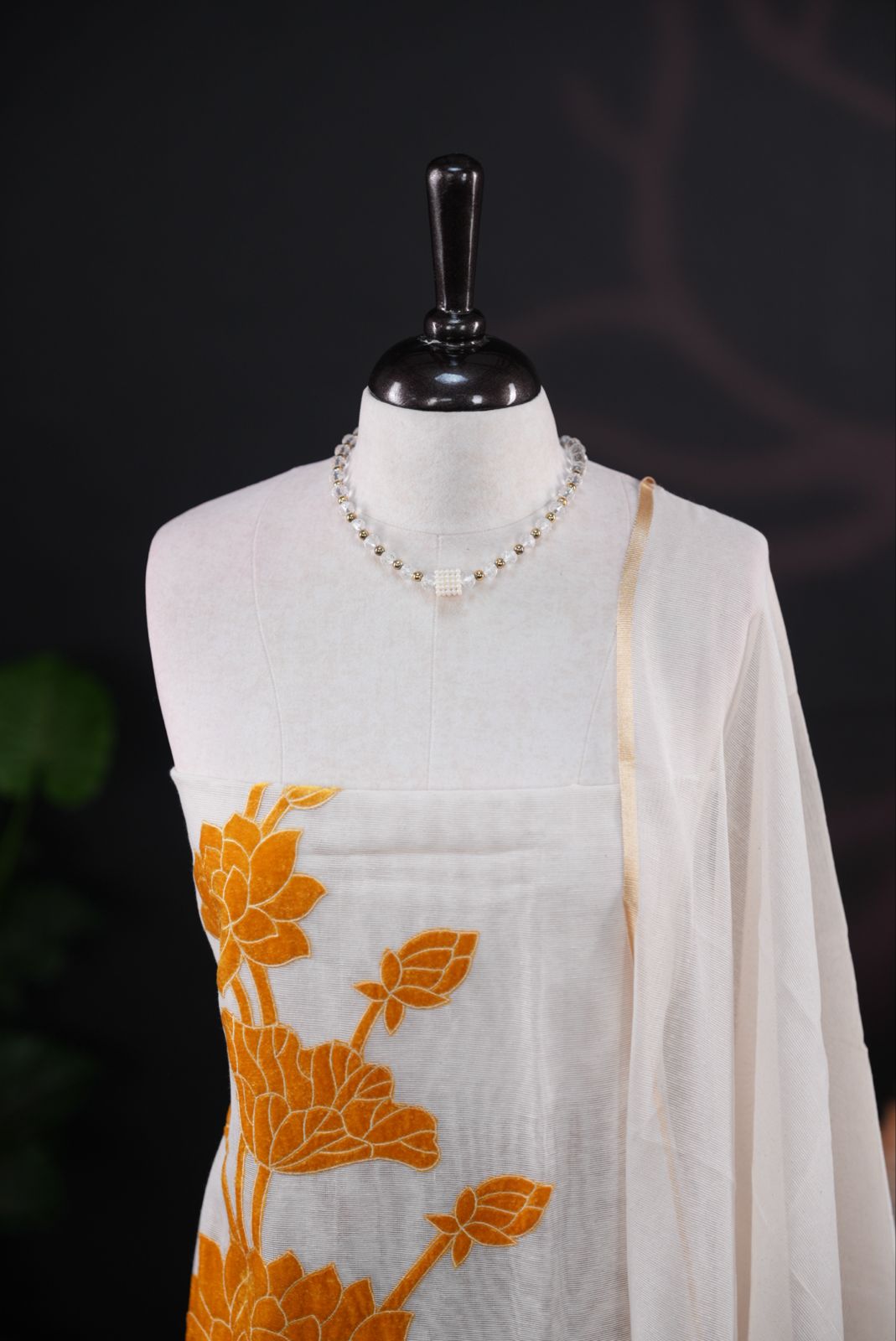 White net kota salwar material featuring Yellow Velvet applique work on body, paired with matching colour santoon bottom, elegant dupatta.