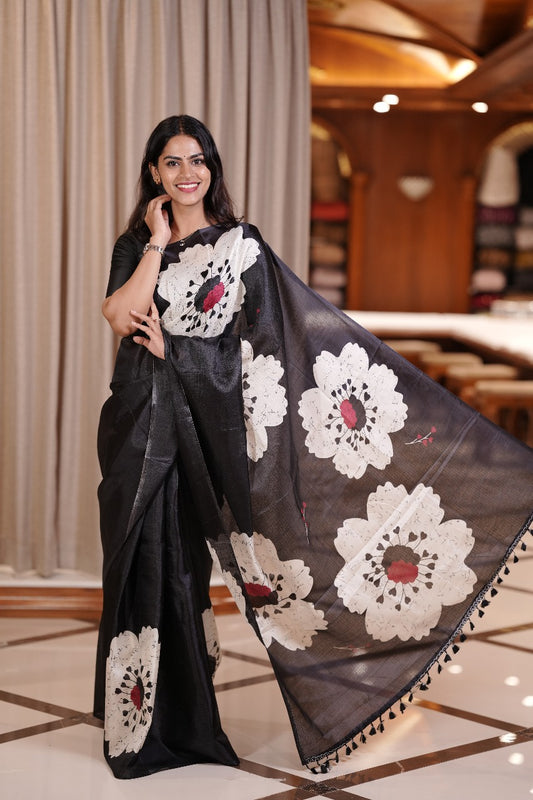 Black colour Semi khadi saree with bold white floral motifs and subtle red accents, exuding timeless elegance and modern charm, paired with a matching blouse.