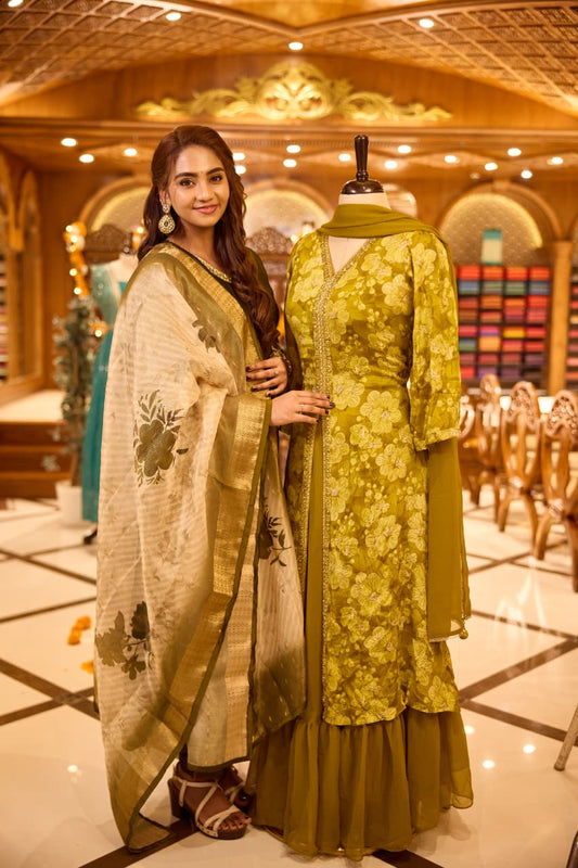 Mustard yellow Anarkali Suit with floral threadwork and sequin detailing on the front, Paired with a plain matching dupatta and gathered flared bottom & A perfect blend of elegance and festive flair.
