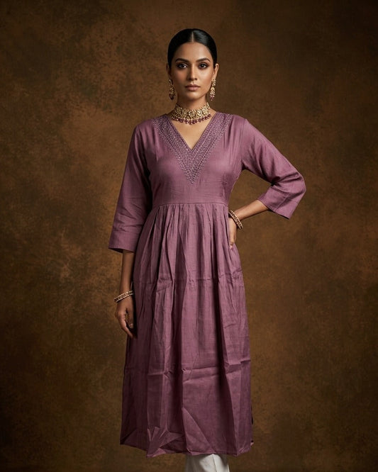 Dark mauve colour kurti highlighted with dainty cutwork along the V-neck yoke, styled with gentle gathers at the waist and comfy 3/4th sleeves.