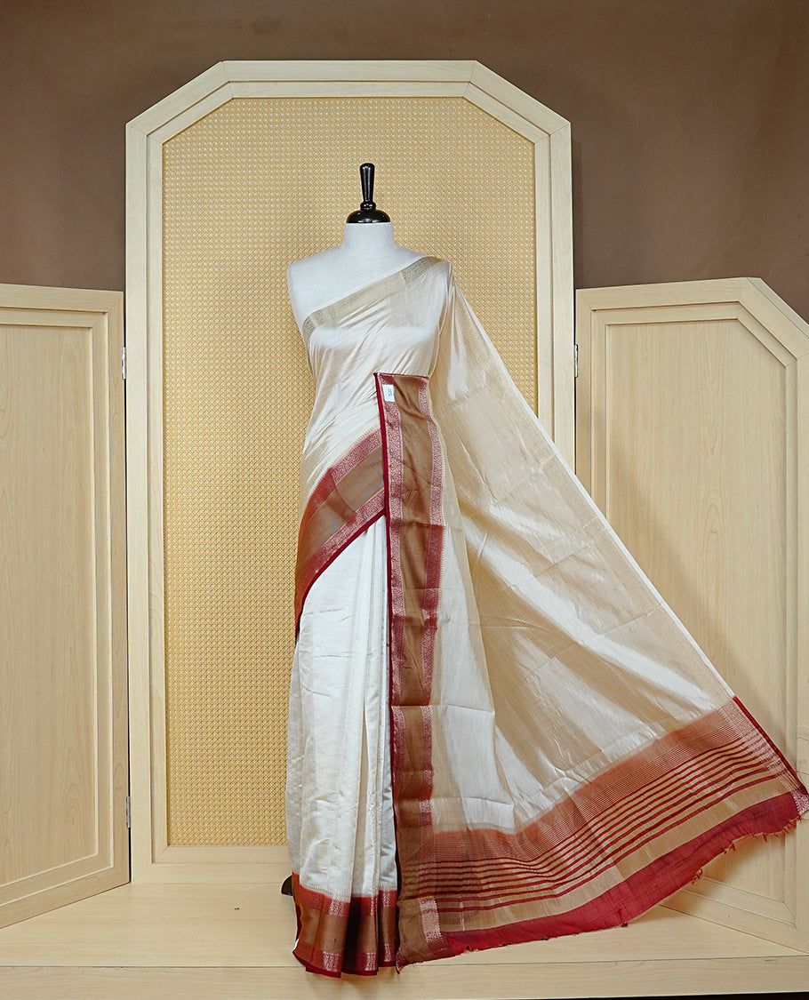 Cream colour semi Tussar silk saree featuring  Elegant body, Complemented by contrast Maroon with rich zari detailed for onam special, paired with contrast Blouse for Festive look.
