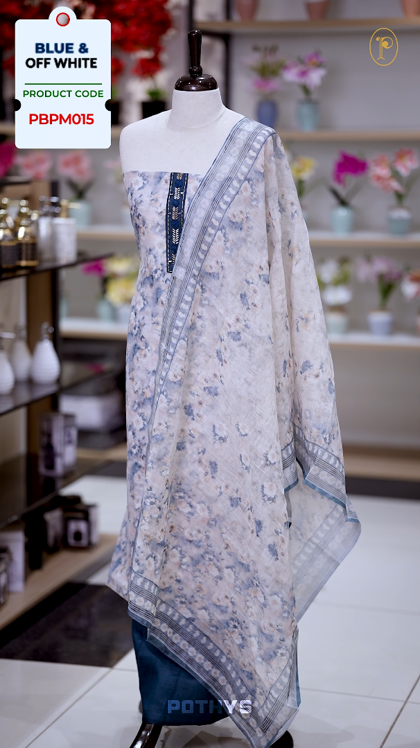 Off white colour jute cotton salwar material with blue leaf prints, featuring embroidery and mirror work on the neckline, paired with a printed dupatta and a contrast blue bottom for a graceful and elegant look.