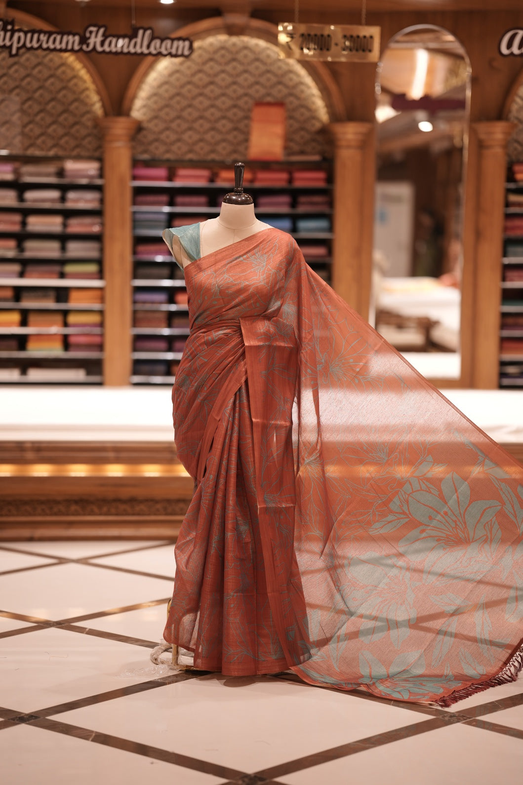 Brick Red & Teal blue colour Semi linen tissue saree featuring full digital floral prints across the body, The saree is highlighted with a contrast floral printed pallu and comes with a plain contrasting blouse piece.