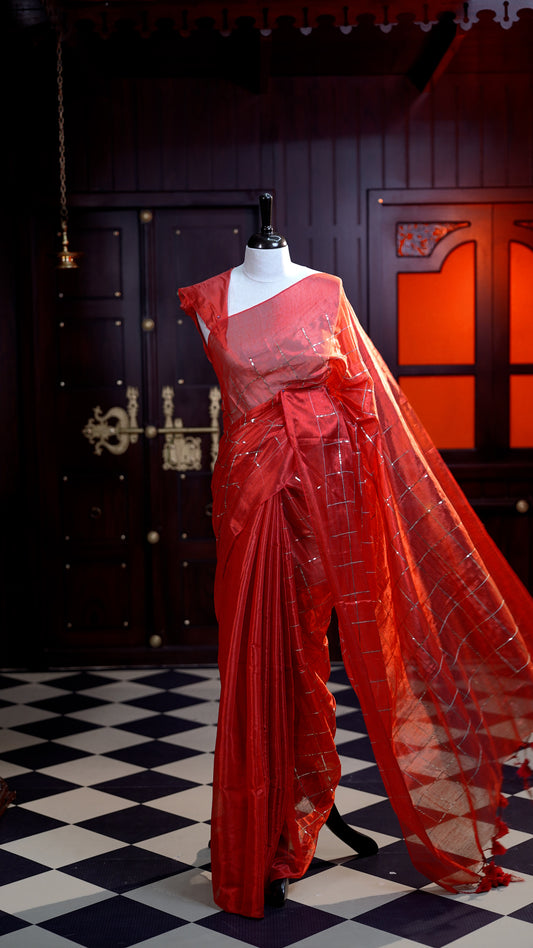 Red colour Semi Tissue Material saree with on all-over check design with silver sequin work on body, comes with a self blouse and a self pallu.