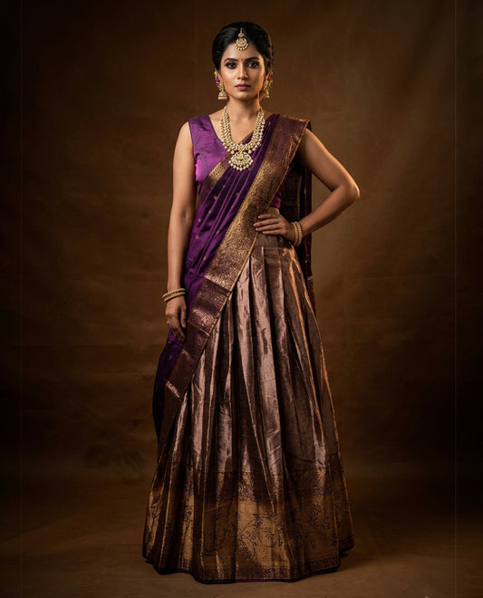 Purple colour Half saree featuring Purple colour skirt with contrast gold colour border with stone work, paired with contrast antique colour stitched blouse piece, with matching dupatta.