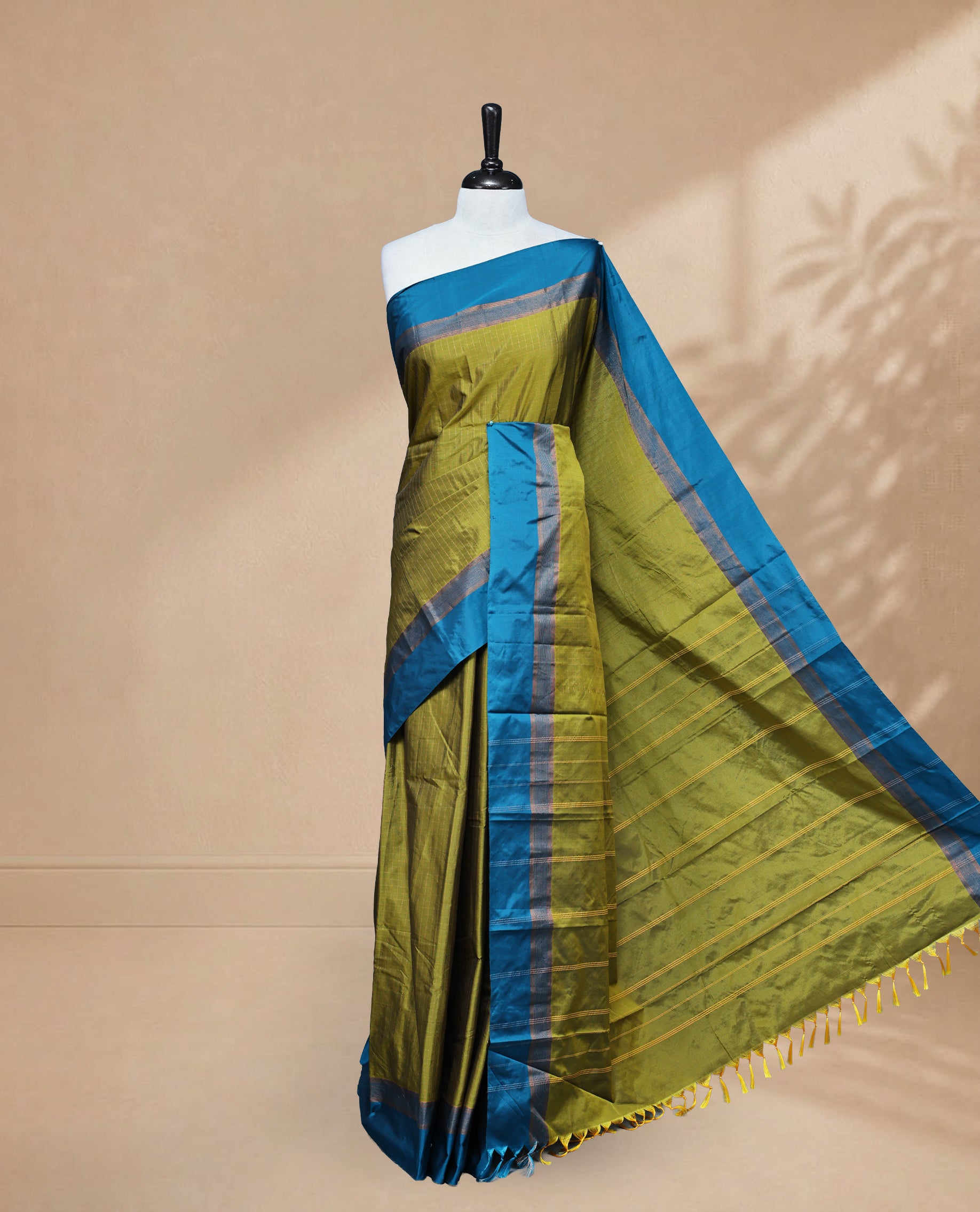 Mehandi colour Semi Silk Saree Featuring Gold zari Small Checks on body, complemented by Contrast Border Detailing, comes with matching blouse piece.