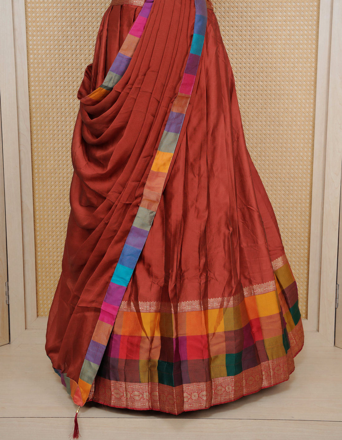 Brick Red colour Semi Silk Semi stitched dhavani set featuring a Plain body with a matching Multi colour with gold zari bordered skirt & blouse piece and dupatta.