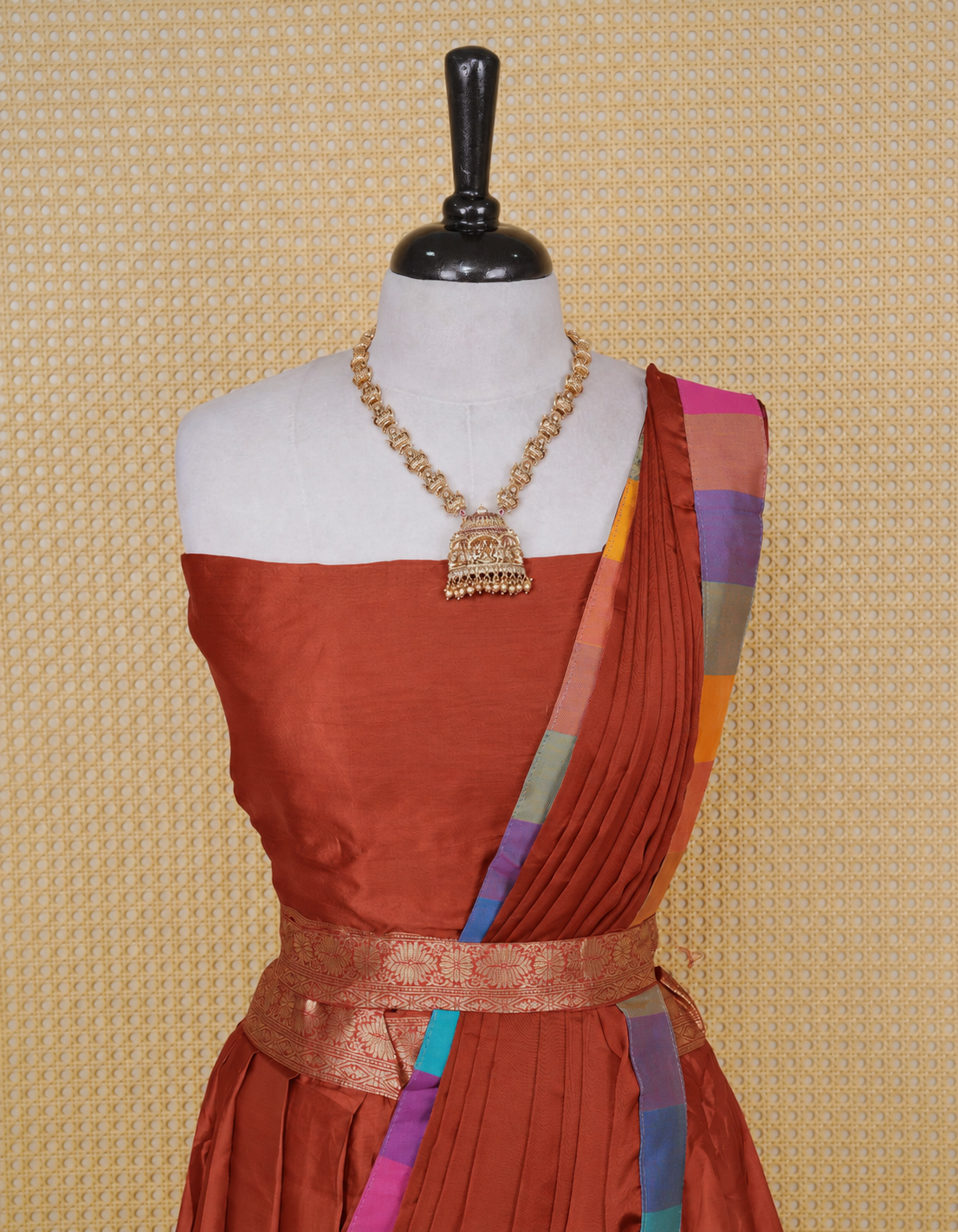 Brick Red colour Semi Silk Semi stitched dhavani set featuring a Plain body with a matching Multi colour with gold zari bordered skirt & blouse piece and dupatta.