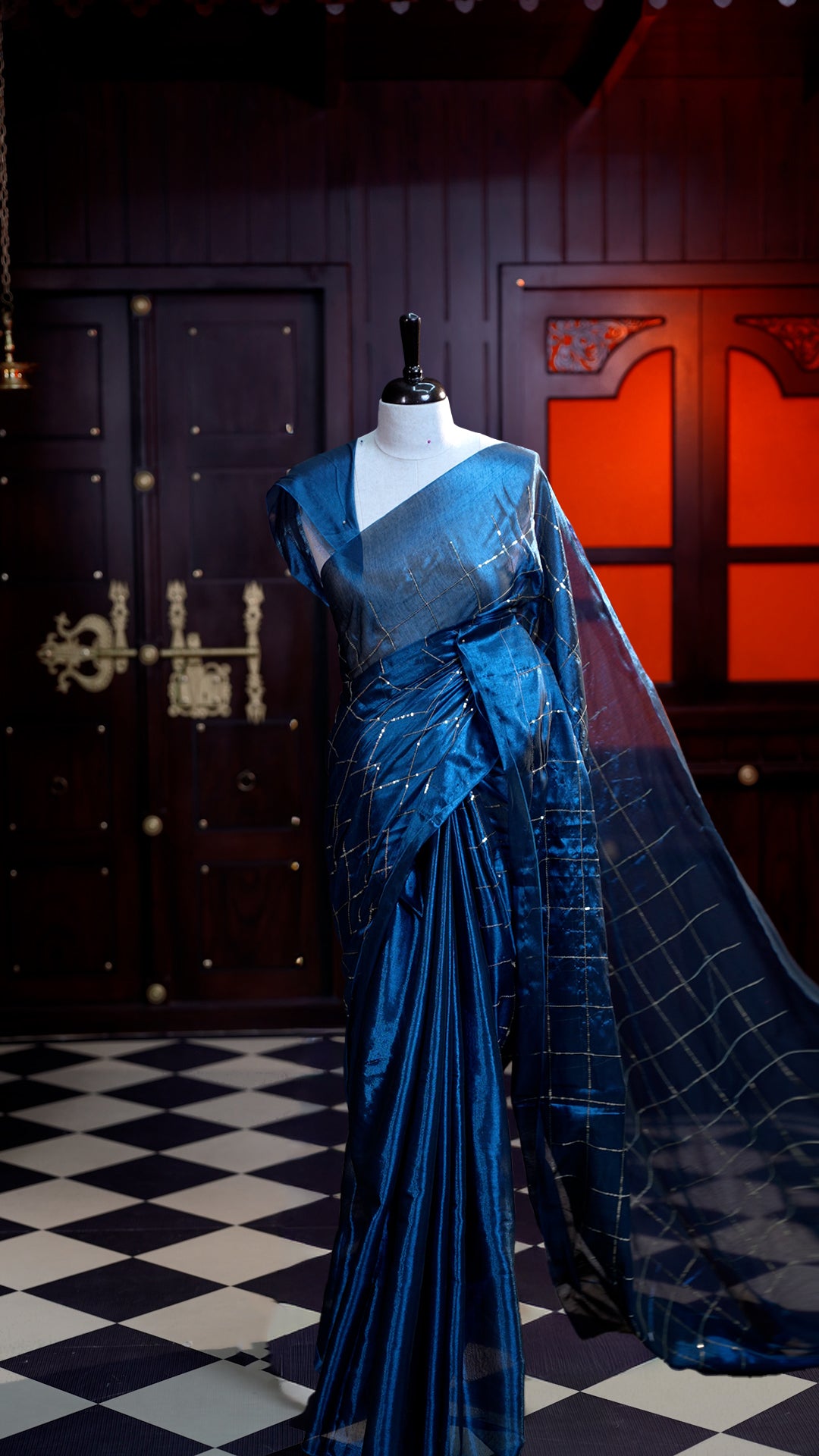 Peacock Blue colour Semi Tissue Material saree with on all-over check design with silver sequin work on body, comes with a self blouse and a self pallu.