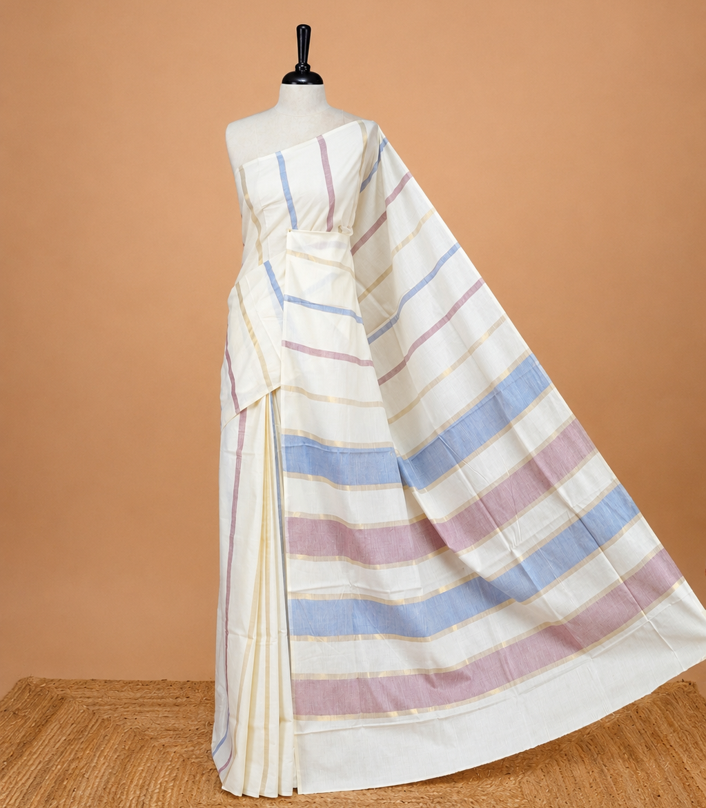 Cream Colour Cotton Kerala Saree Featuring Periwinkle  Blue & Light  Purple Strips On The Body & Pallu, Paired With A Matching Blouse Piece.