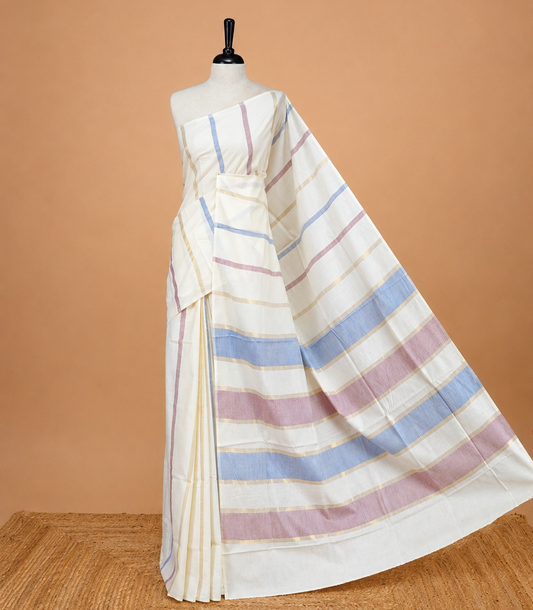 Cream Colour Cotton Kerala Saree Featuring Periwinkle  Blue & Light  Purple Strips On The Body & Pallu, Paired With A Matching Blouse Piece.