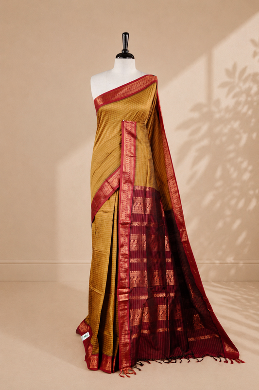 Mustard colour kalyani cotton saree featuring antique zari check pattern on body, complemented by Maroon colour with Antique zari border, paired with matching blouse piece.