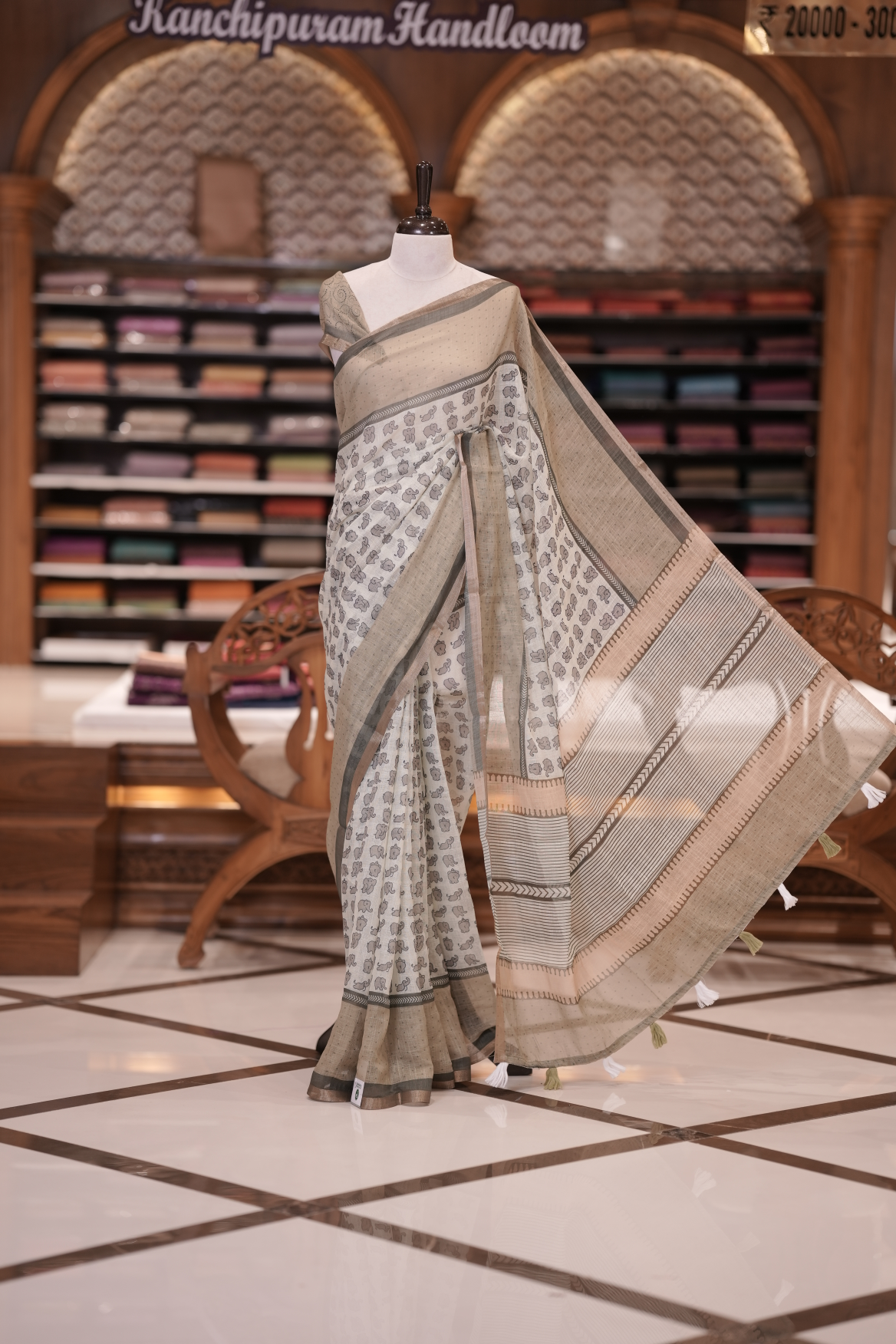Pastel Green colour soft linen saree adorned with cute elephant prints all over the body, complemented by a contrast woven border and paired with a matching printed blouse piece
