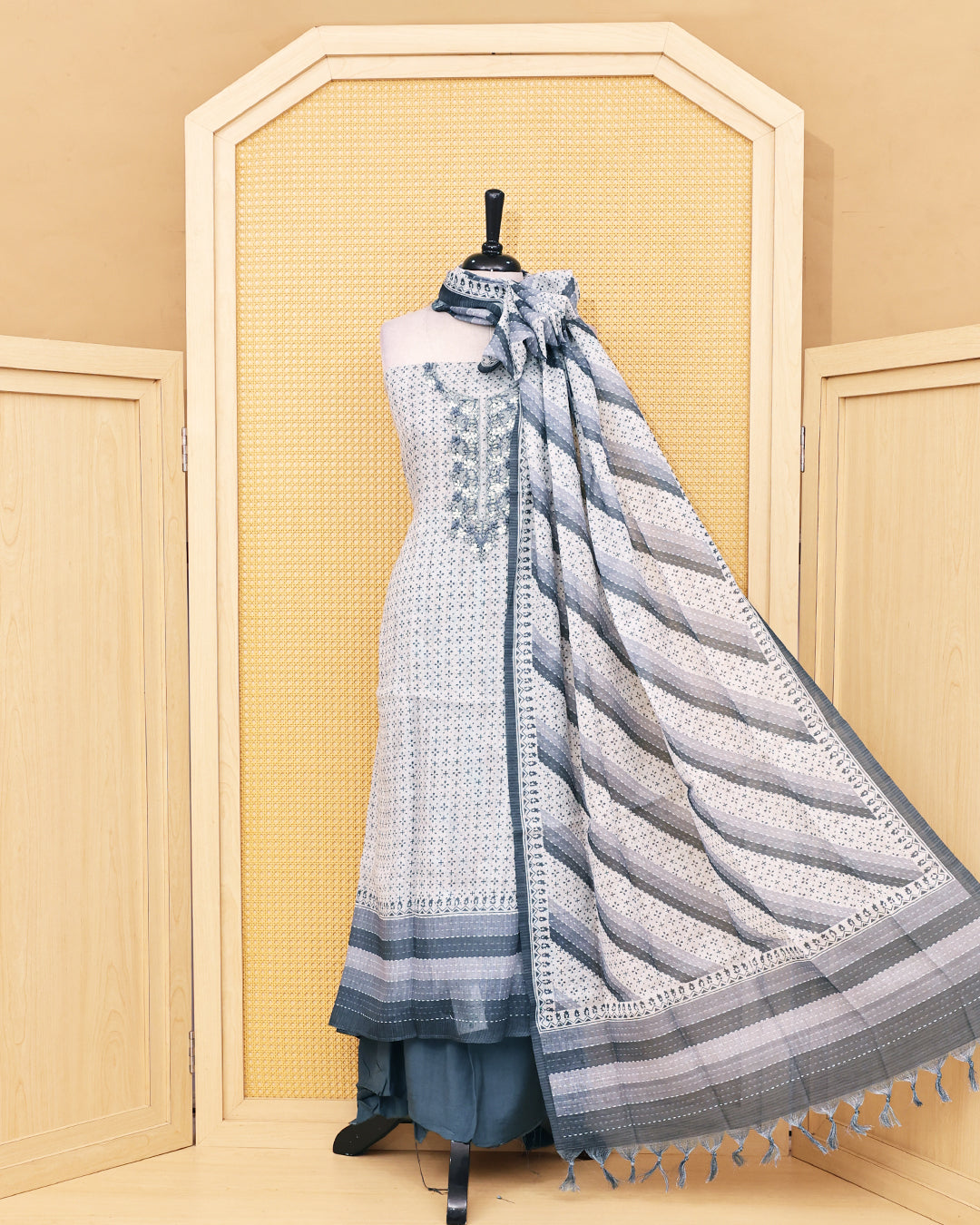 Cream colour Linen Salwar Material with  Printed body ,delicate floral embroidery on yoke, paired with a solid slate grey bottom and a beautifully striped printed dupatta with tassel detailing