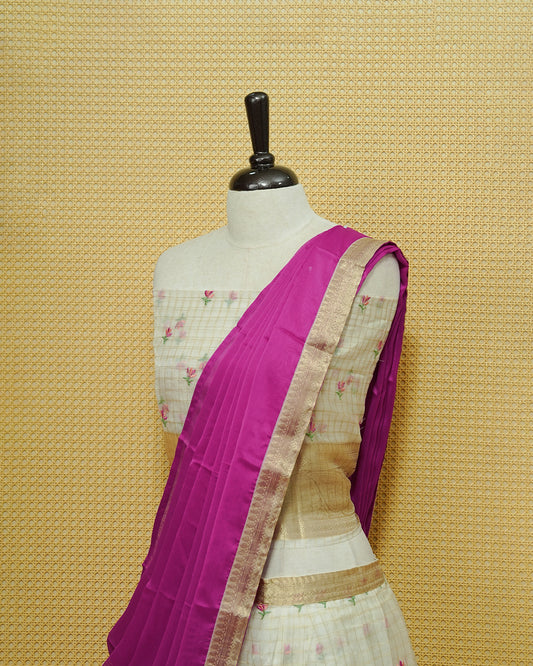 Cream colour Semi stitched Dhavani set featuring Gold zari checked pattern with floral motifs on skirt with traditional border, comes with contrast Colour Dupatta & matching blouse piece.