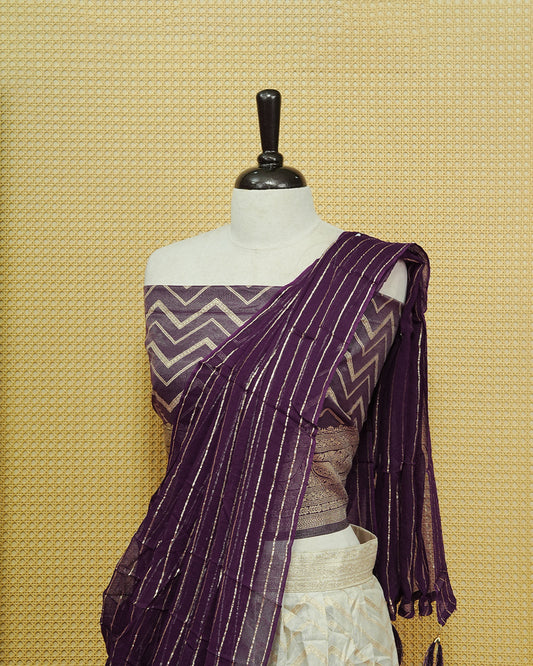 Cream colour Semi Stitched Dhavani set Featuring Gold zari Zigzag pattern With Traditional border skirt, Contrast Purple colour Dupatta, Matching blouse piece.