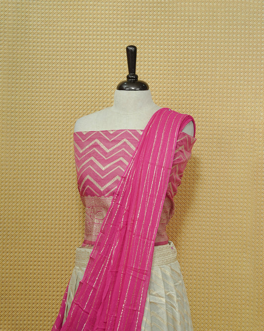 Cream colour Semi Stitched Dhavani set Featuring Gold zari Zigzag pattern With Traditional border skirt, Contrast Pink colour Dupatta, Matching blouse piece.