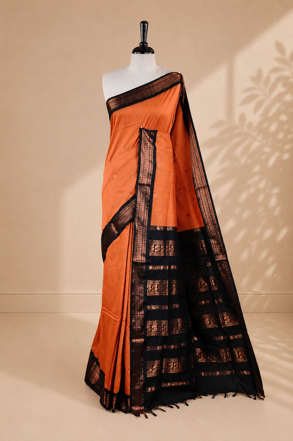 Orange colour kalyani cotton saree featuring antique zari motifs on body, complemented by Black colour with Antique zari border, paired with matching blouse piece.