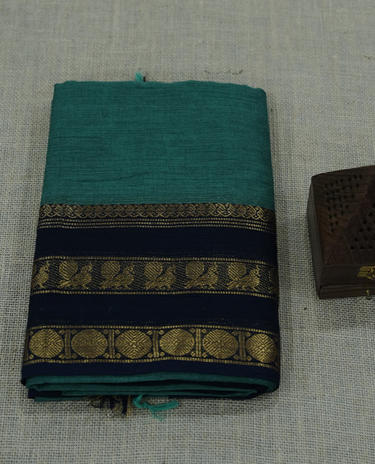 Teal green saree highlighted with bold black panels and intricate gold zari borders.