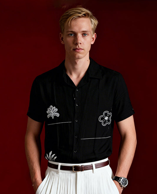 Black colour shirt featuring elegant white embroidery motifs on the body, Designed with a classic shirt collar and short sleeves, it blends contemporary style with subtle detailing.