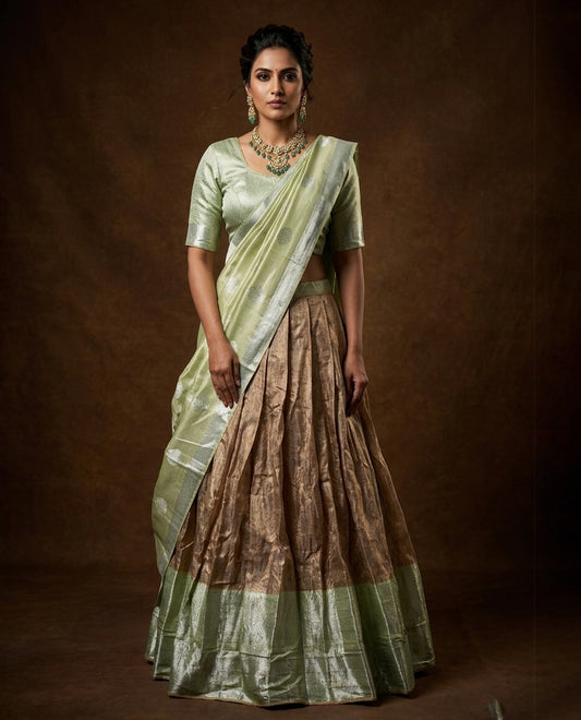 Pastel green colour Half saree featuring Antique colour skirt with contrast dusted gold colour border, paired with matching stitched blouse piece, with matching dupatta.