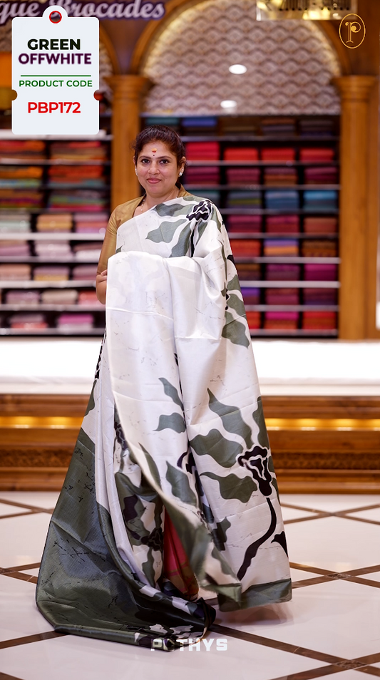 Olive green and off white colour saree with bold black floral prints enhancing its modern charm & Crafted from soft, lightweight fabric for elegant draping, this saree comes paired with a matching blouse piece.