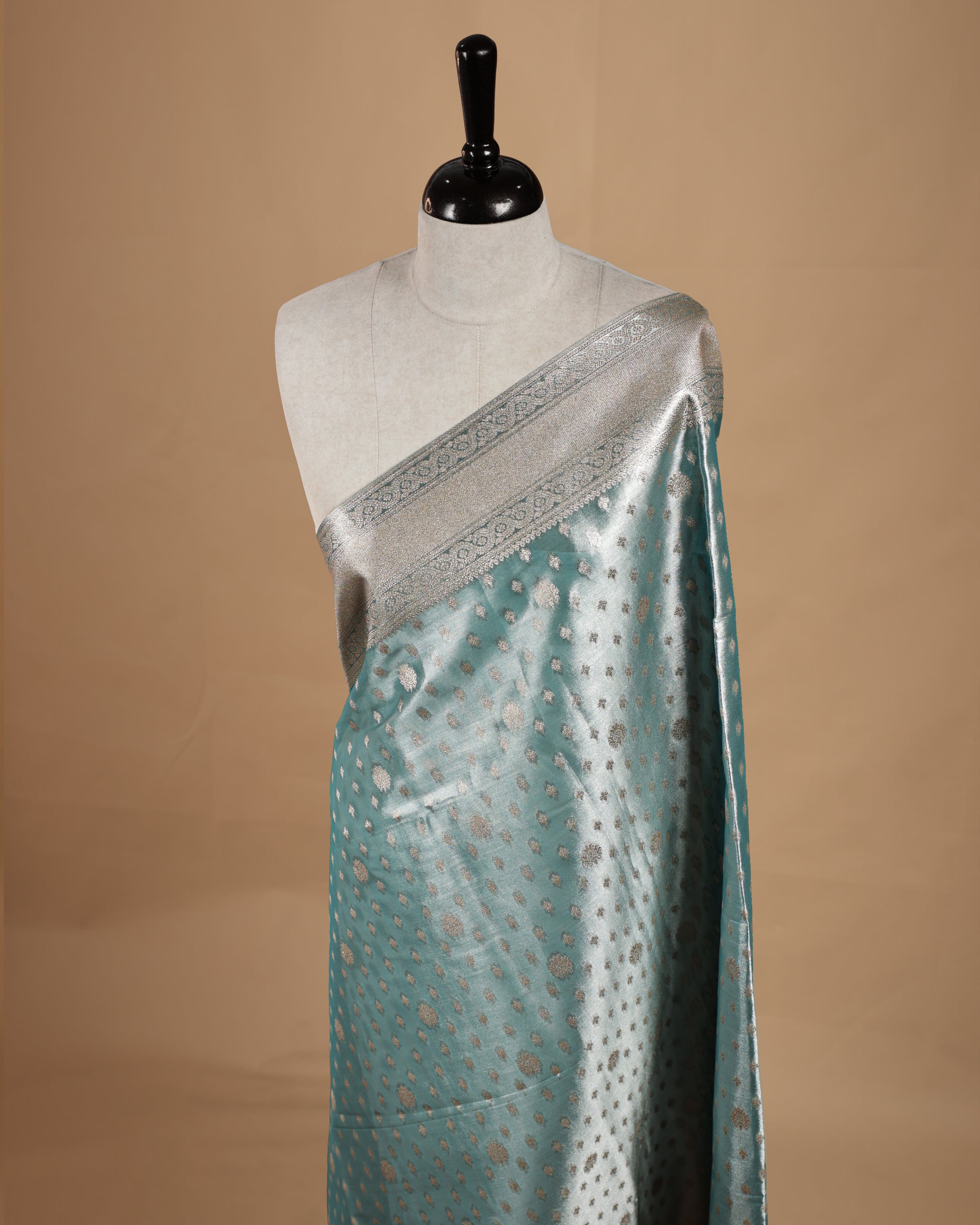 Pastel Aqua colour semi tissue silk saree featuring floral zari motifs on body, complemented by gold zari traditional border, paired with matching blouse piece.