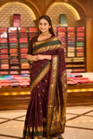 Dark maroon colour pure Kancheepuram saree with gold zari Banarasi paisley peacock motifs on the body traditional green border with peacock pattern grand pallu with floral  motifs paired with matching blouse.